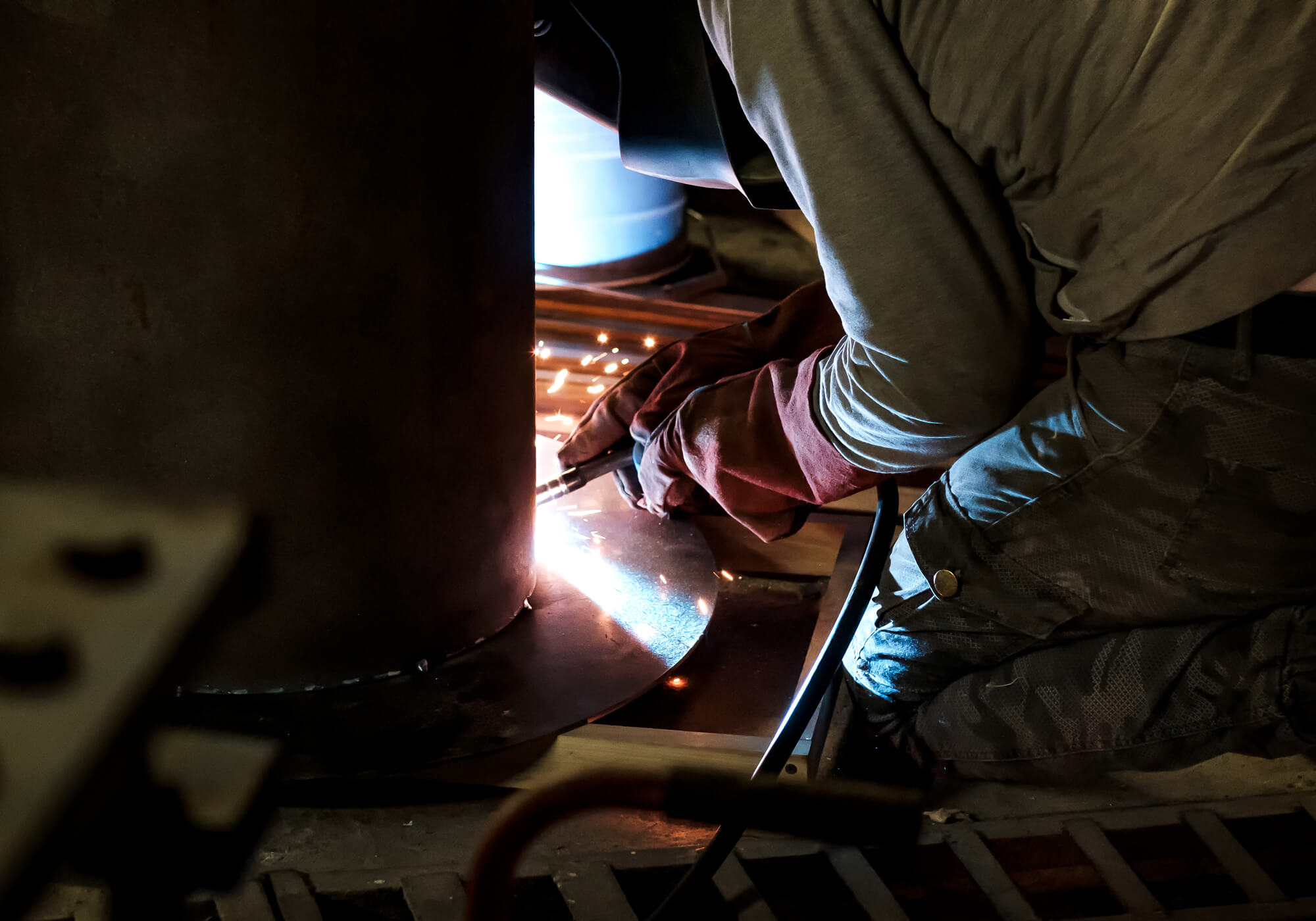 man-in-protective-gloves-cutting-metal-using-angle-BHWNSAT